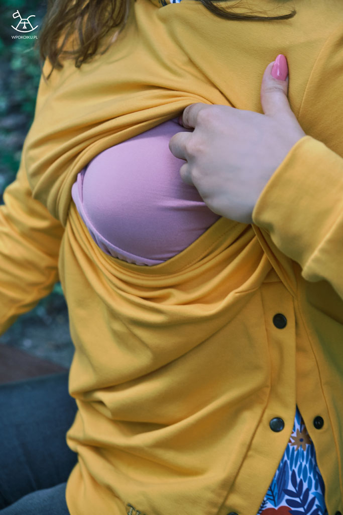 kobieta prezentuje otwór w bluzie do karmienia piersią